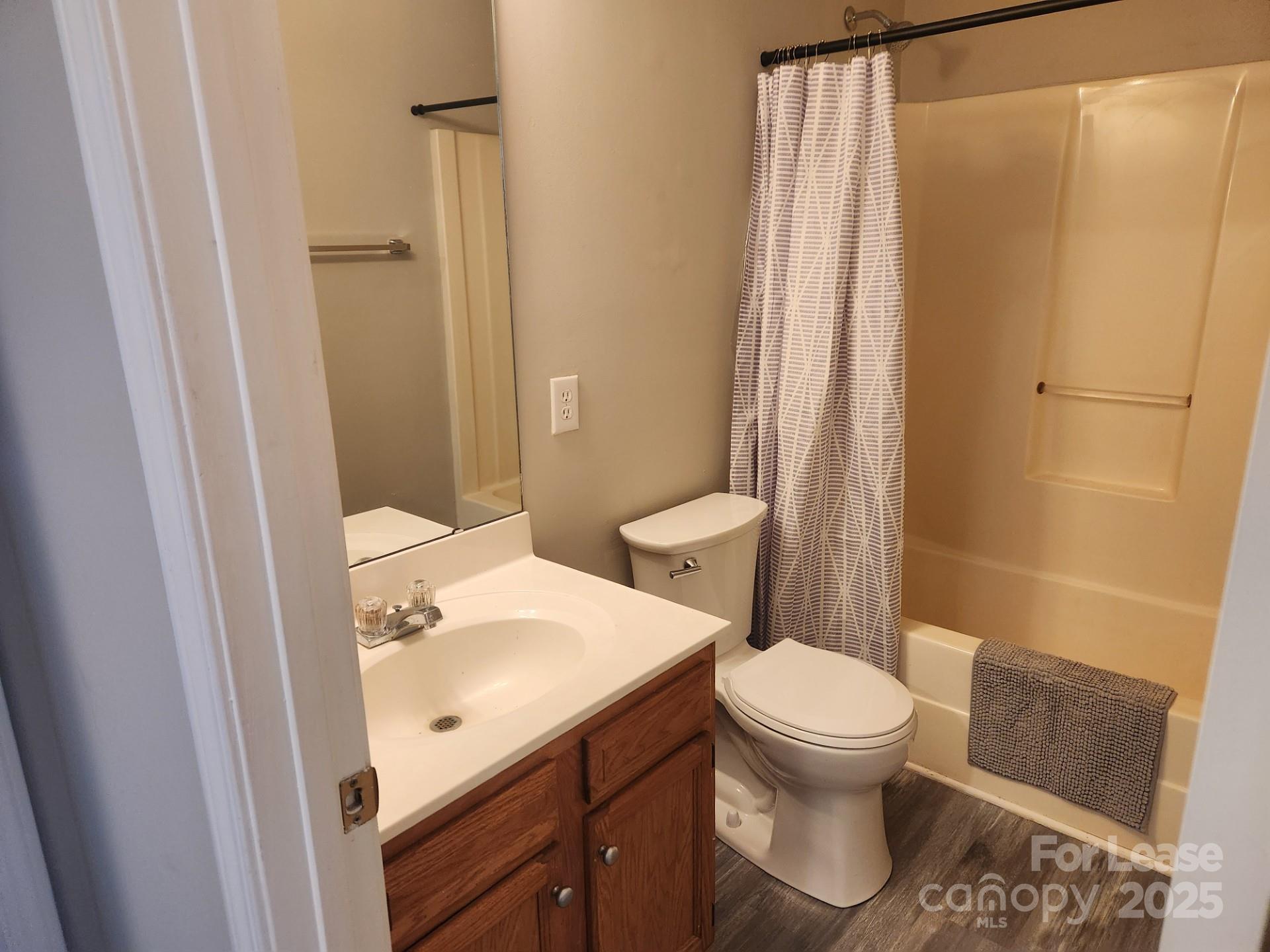 157 Pounds Avenue Southwest Concord, NC 28025 - Photo 9 of 15 a bathroom with a sink a toilet a shower and a mirror