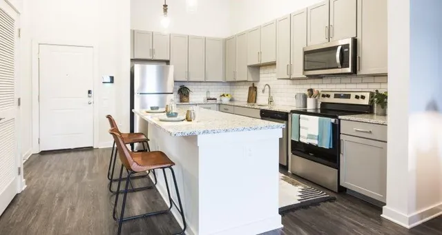 a kitchen with stainless steel appliances a stove a sink refrigerator and a microwave