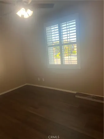 en empty room with wooden floor and window