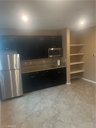 a kitchen with cabinets and refrigerator