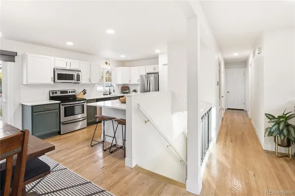 a kitchen with a sink a counter top space stainless steel appliances and cabinets