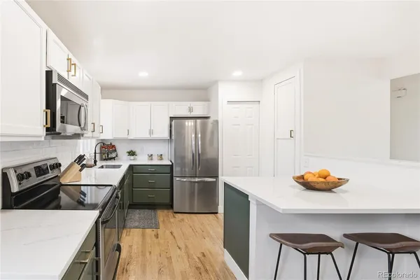 a kitchen with stainless steel appliances granite countertop a refrigerator and a stove top oven