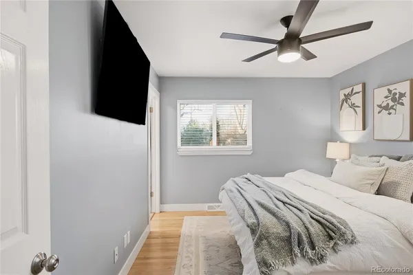 a bedroom with a bed and a flat tv screen on the dresser