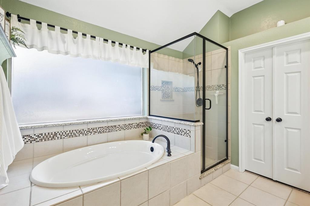 524 Post Oak Road Grapevine, TX 76051 - Photo 25 of 37 Soaking tub with black-finish faucet, tile surround, and mosaic tile accent
