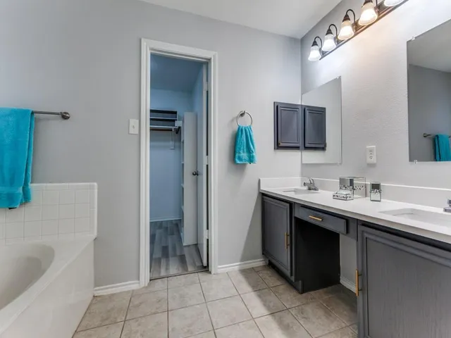 a bathroom with a tub sink and mirror