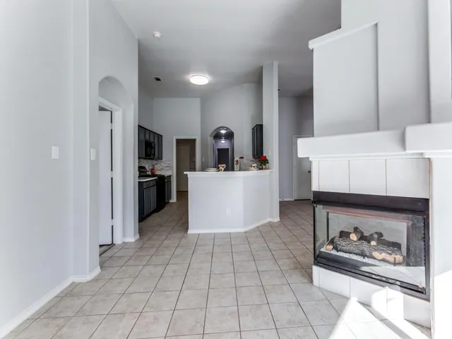 a view of an empty room with window and cabinet