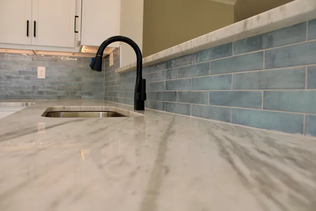 a kitchen with stainless steel appliances granite countertop a sink and a stove top oven