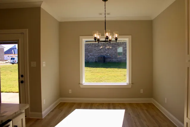 a view of empty room with wooden floor and a fireplace
