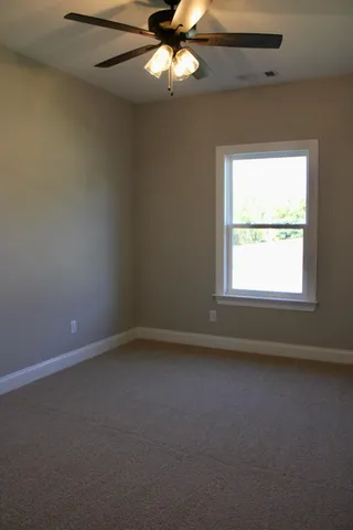 an empty room with a window and a fan