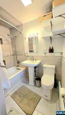 a bathroom with a sink toilet a mirror and bathtub