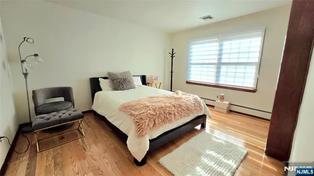 a bedroom with a bed wooden floor and window