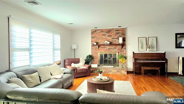 a living room with furniture a fireplace and a large window
