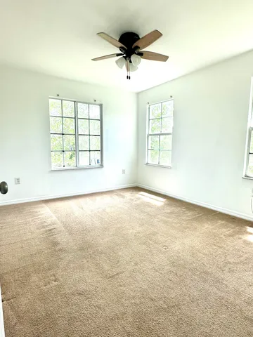 an empty room with a window and a ceiling fan