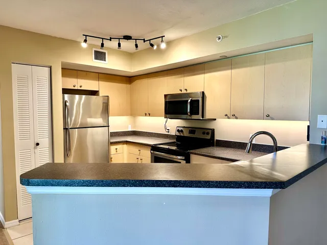 a kitchen with stainless steel appliances granite countertop a sink refrigerator and microwave