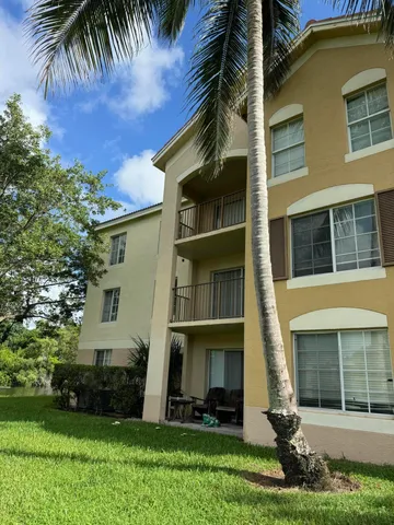 a front view of a house with a garden and trees