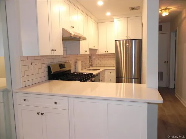 a kitchen with stainless steel appliances granite countertop a refrigerator and a sink
