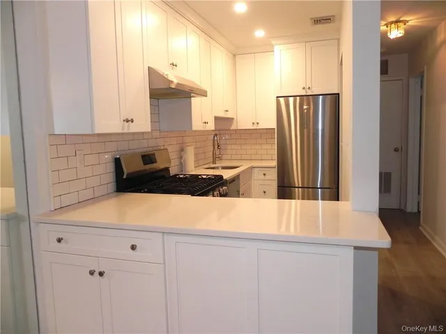 a kitchen with stainless steel appliances granite countertop a refrigerator and a sink
