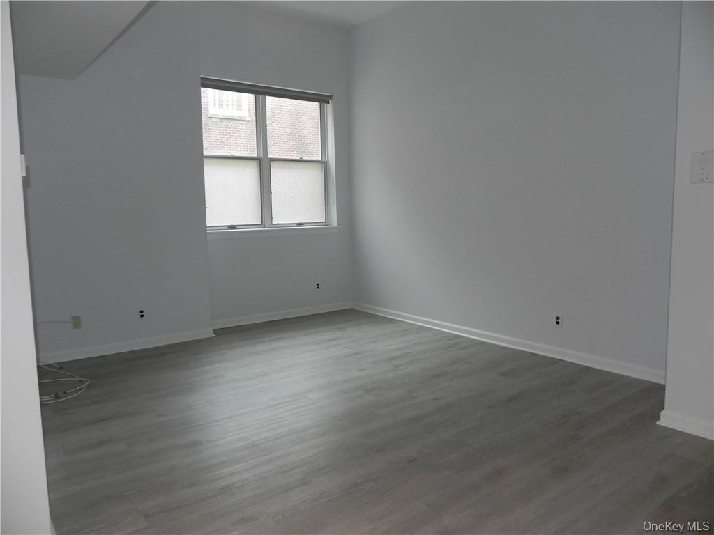 1250 North Avenue, Unit 209 New Rochelle, NY 10804 - Photo 8 of 26 an empty room with wooden floor and windows