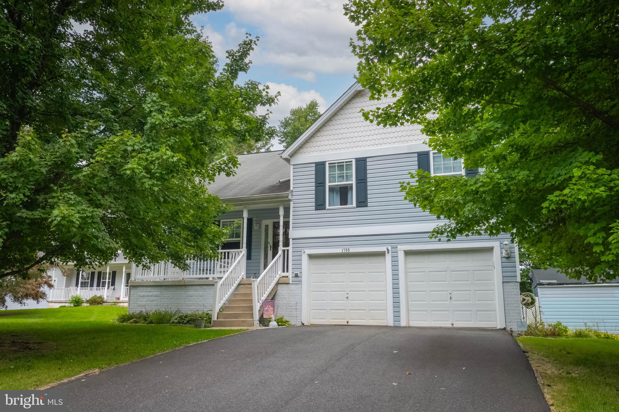 a view of a house with a yard and large tree