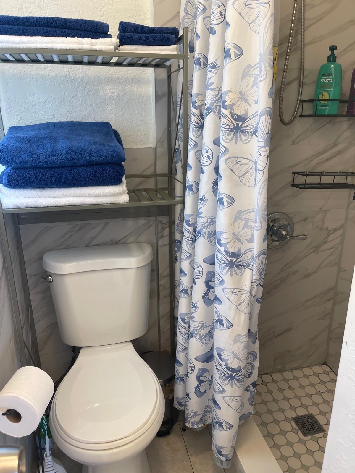 2776 Seminole Road Palm Springs, FL 33406 - Photo 22 of 24 a white toilet sitting next to a shower curtain