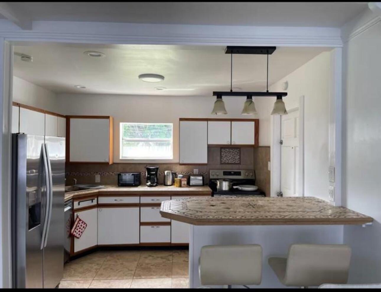 2776 Seminole Road Palm Springs, FL 33406 - Photo 9 of 24 a kitchen with stainless steel appliances granite countertop a sink stove and refrigerator