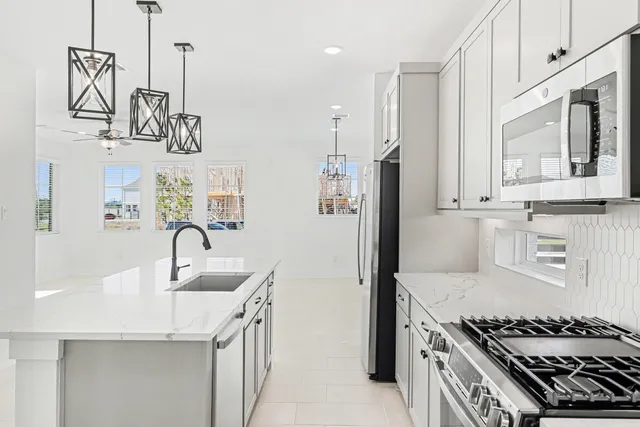 a kitchen with kitchen island granite countertop a sink a stove oven a counter top space and cabinets