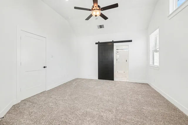 an empty room with windows and fan