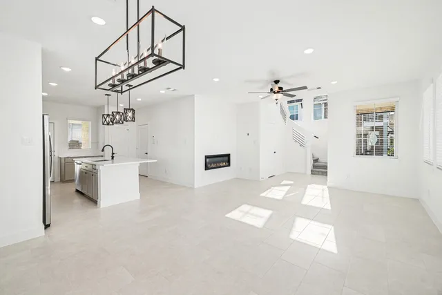 a living room with stainless steel appliances kitchen island furniture and a chandelier