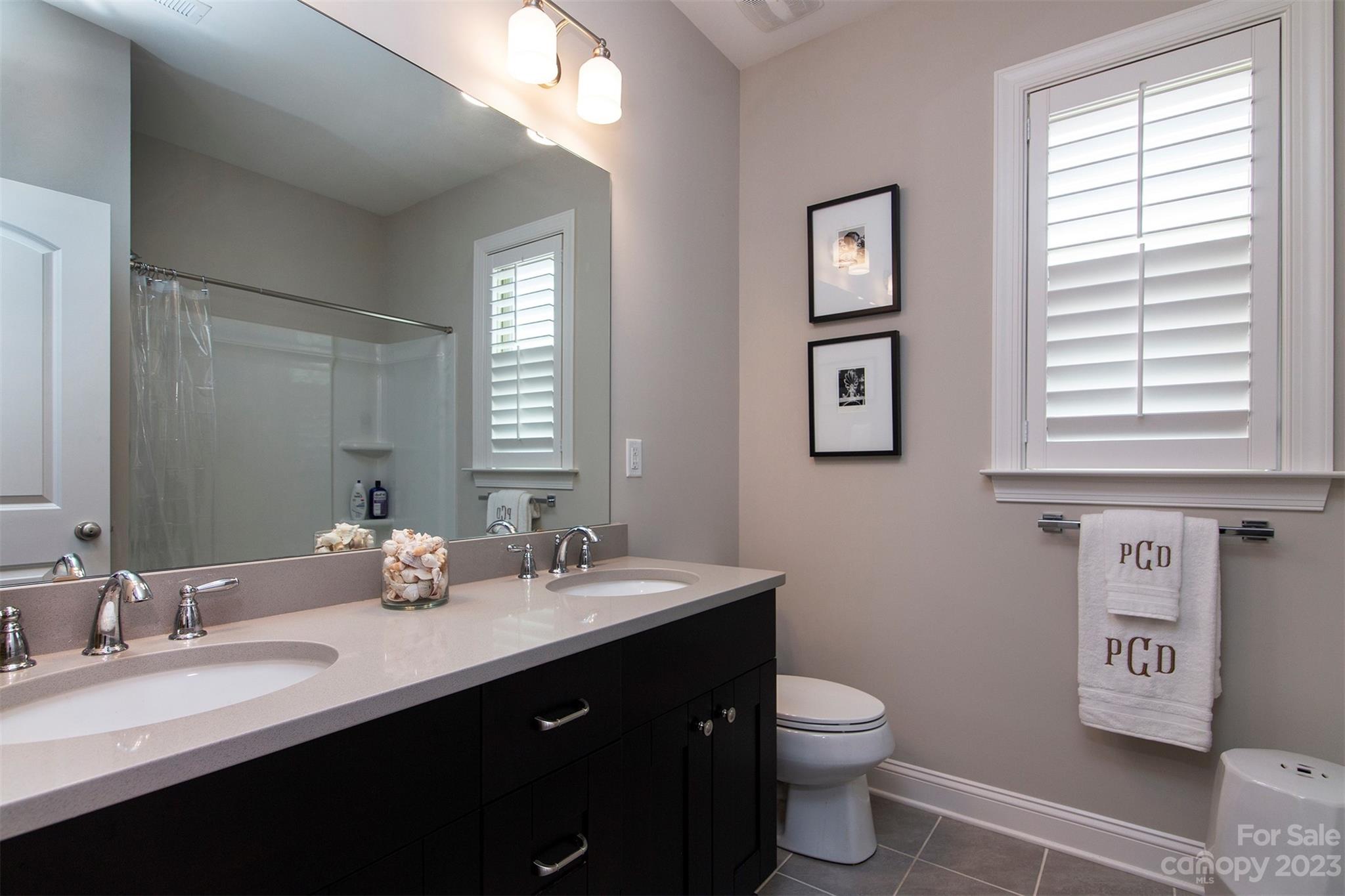 15111 Rocky Bluff Loop Davidson, NC 28036 - Photo 15 of 24 a bathroom with a double vanity sink toilet and a mirror