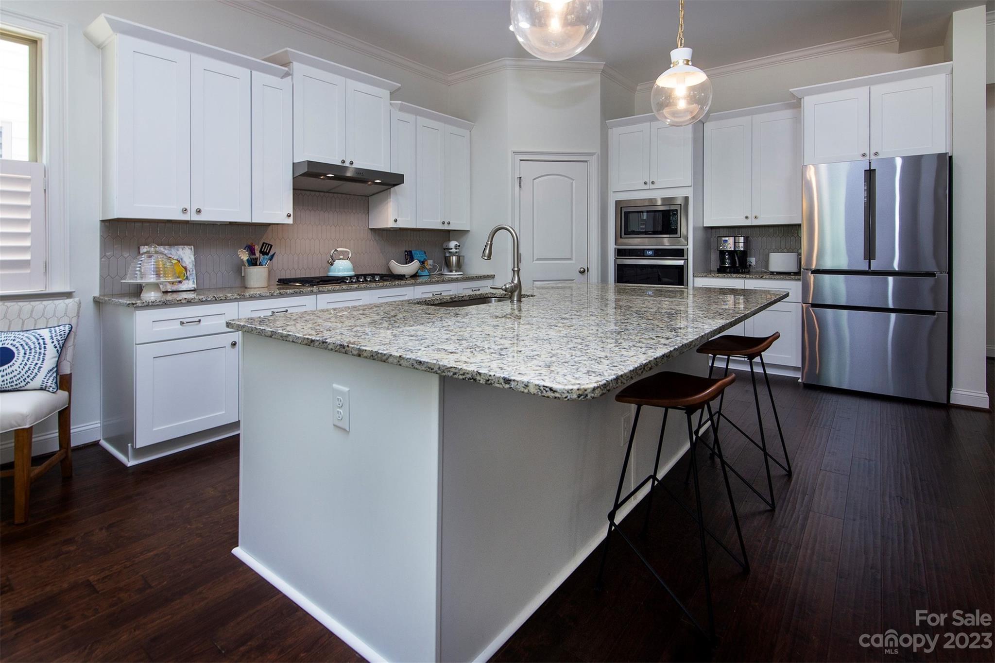 15111 Rocky Bluff Loop Davidson, NC 28036 - Photo 6 of 24 a kitchen with stainless steel appliances granite countertop a refrigerator a stove a sink dishwasher and a refrigerator with wooden floor