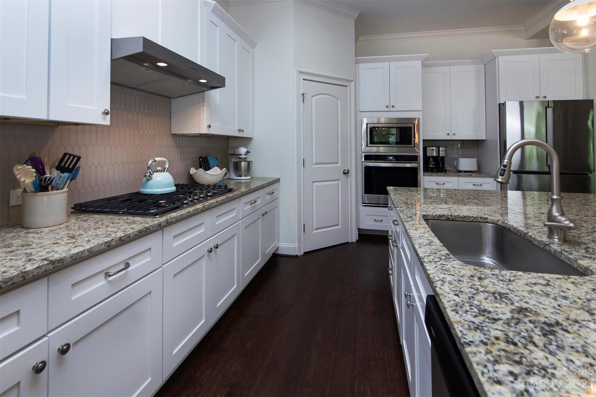 15111 Rocky Bluff Loop Davidson, NC 28036 - Photo 7 of 24 a kitchen with stainless steel appliances granite countertop a sink stove and refrigerator