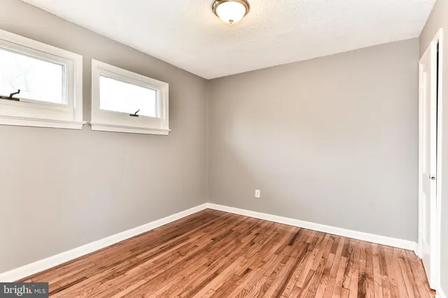 a view of a room with wooden floor and windows