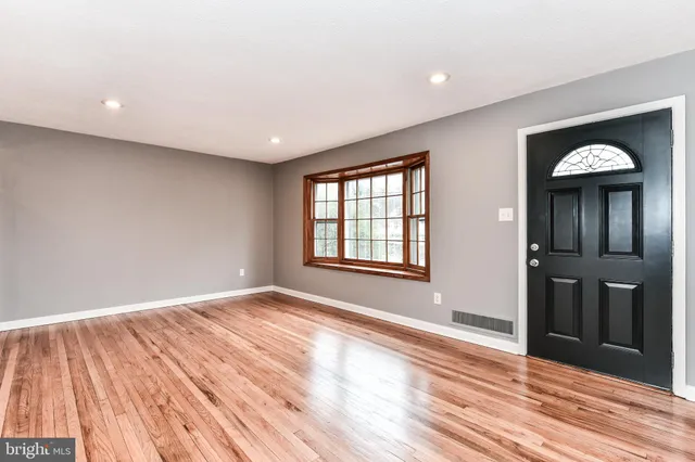 a view of a room with wooden floor and a window