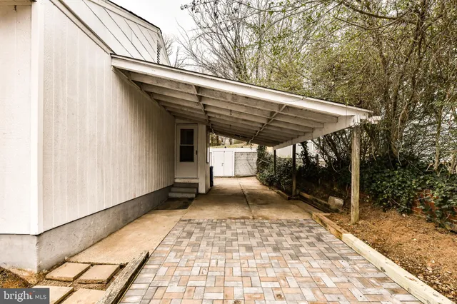 a view of a patio with table and chairs under an umbrella with a barbeque