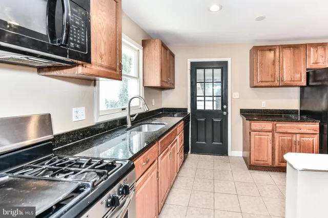 a kitchen with stainless steel appliances granite countertop a stove and a sink