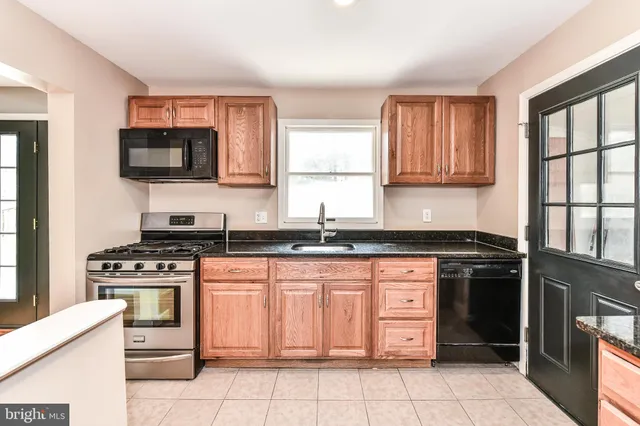 a kitchen with stainless steel appliances granite countertop a stove top oven a sink dishwasher and granite counter tops