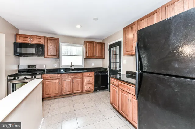 a kitchen with stainless steel appliances granite countertop a refrigerator a stove top oven a sink and dishwasher