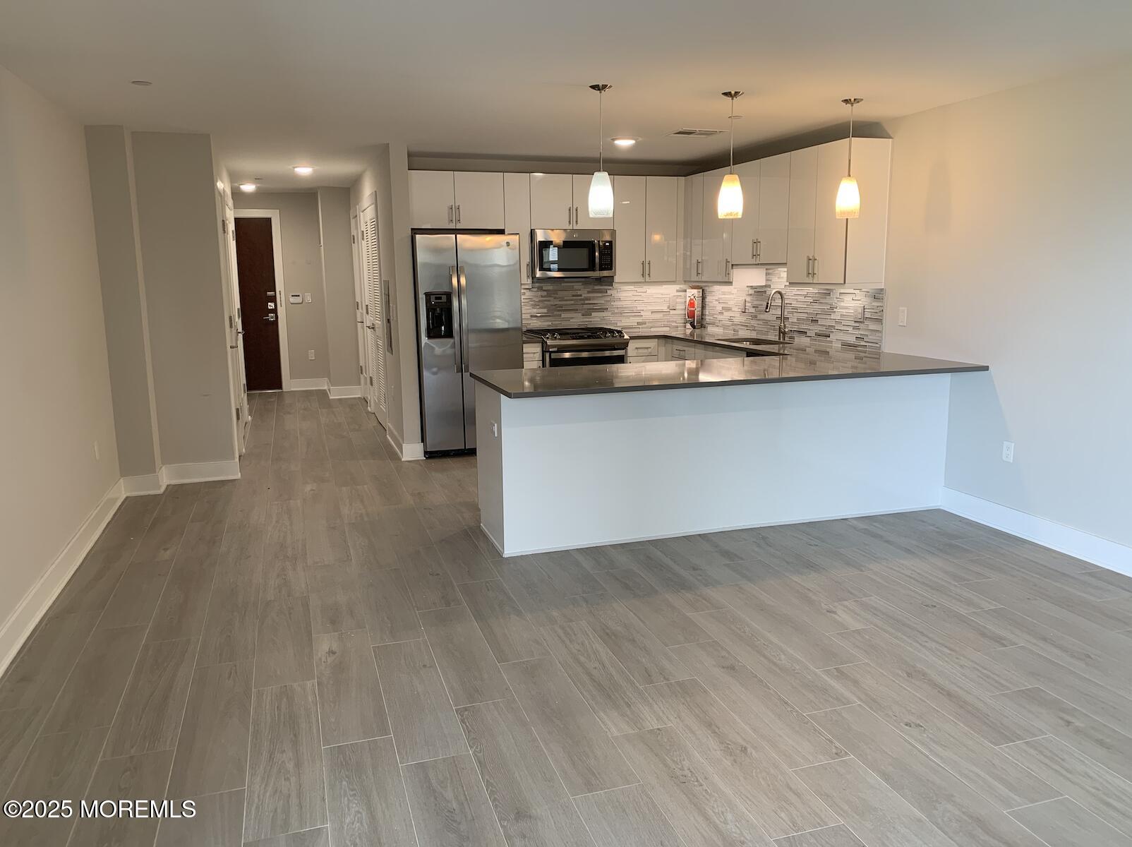 345 Ocean Boulevard, Unit 402 Long Branch, NJ 07740 - Photo 3 of 9 a view of kitchen view with wooden floor and stainless steel appliances
