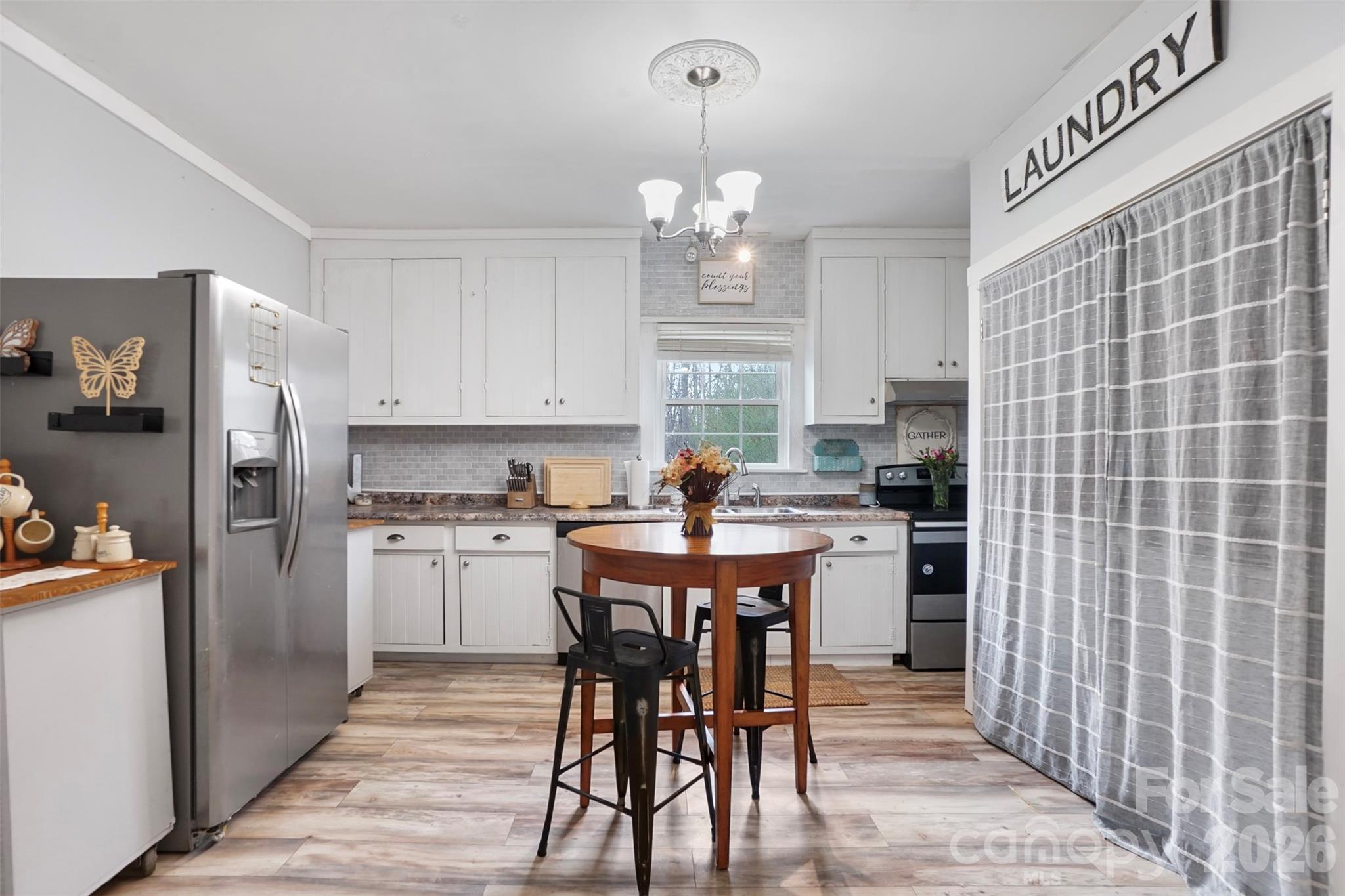 409 Blacksnake Road Stanley, NC 28164 - Photo 17 of 28 a kitchen with refrigerator cabinets dining table and chairs