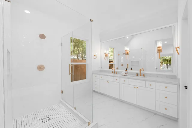 a bathroom with a granite countertop toilet sink and mirror