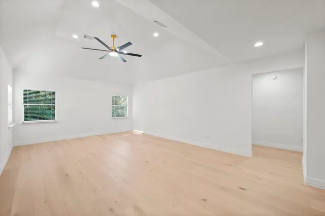 an empty room with a window and a fan