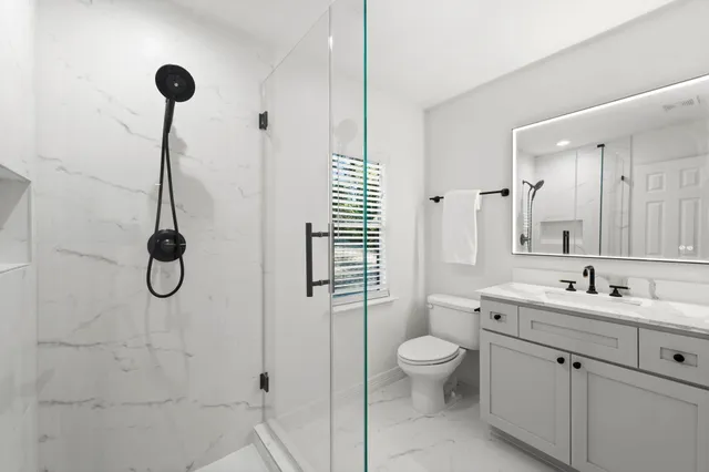 a bathroom with a sink a toilet and shower