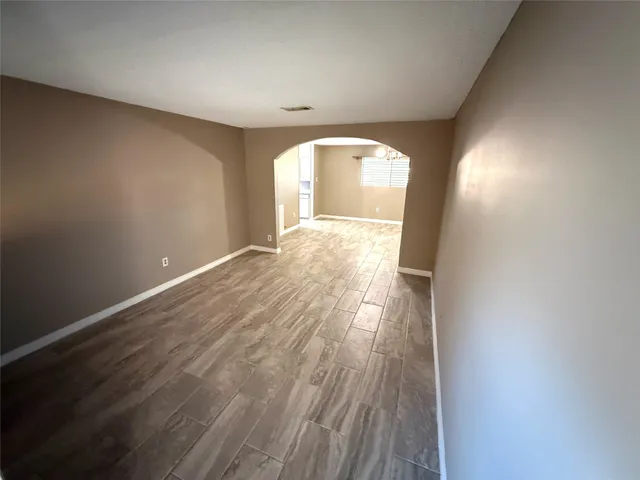 a view of a big room with wooden floor and windows