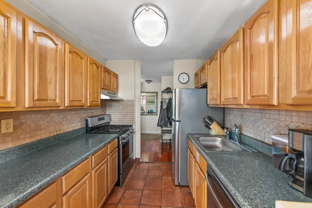 a kitchen with stainless steel appliances granite countertop a sink a stove and a refrigerator