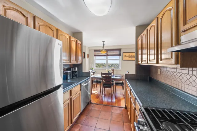 a kitchen with stainless steel appliances a counter top space a stove and a window