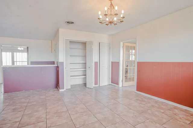an empty room with closet and a ceiling fan