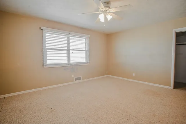 a view of an empty room with a ceiling fan