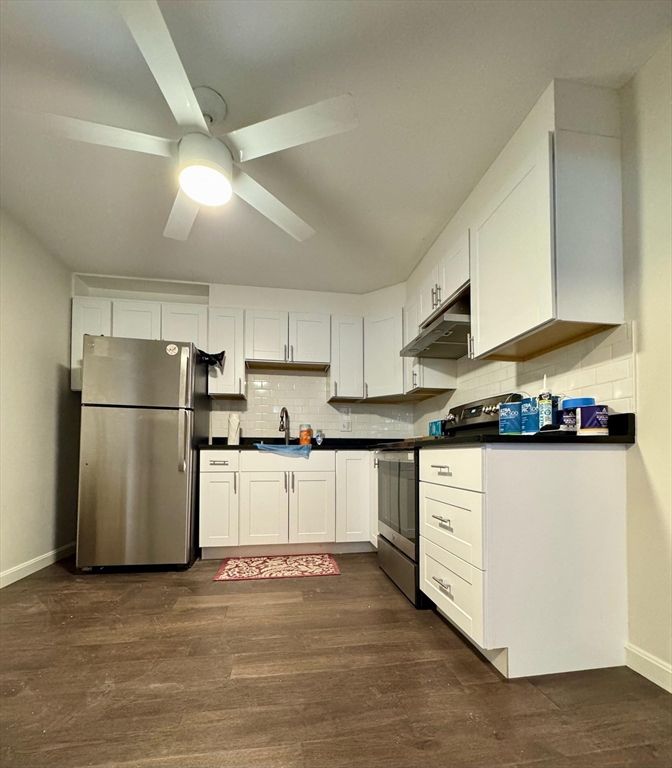 a kitchen with a refrigerator and a stove top oven