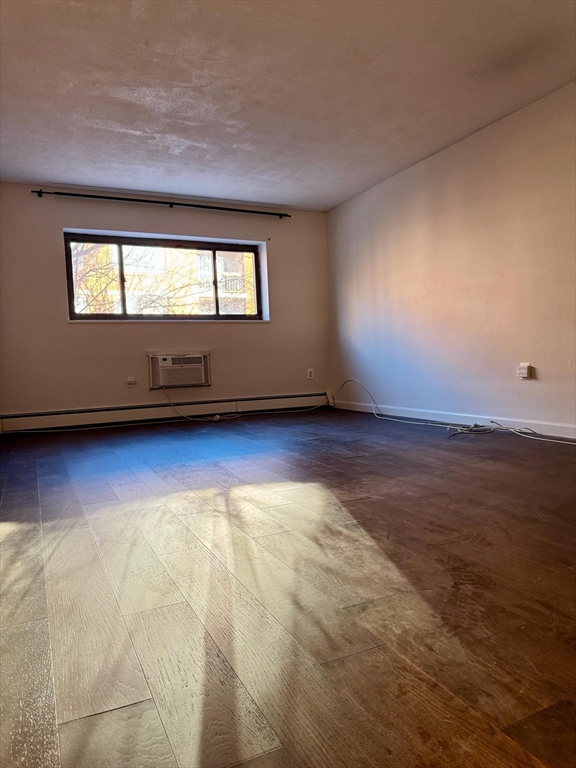 15 Walbridge Street, Unit 23 Boston, MA 02134 - Photo 8 of 14 a view of an empty room with wooden floor and a window