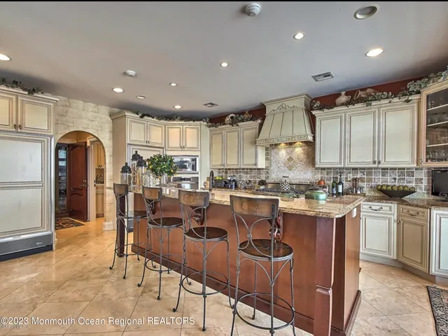 a kitchen with stainless steel appliances granite countertop a stove a sink and white cabinets